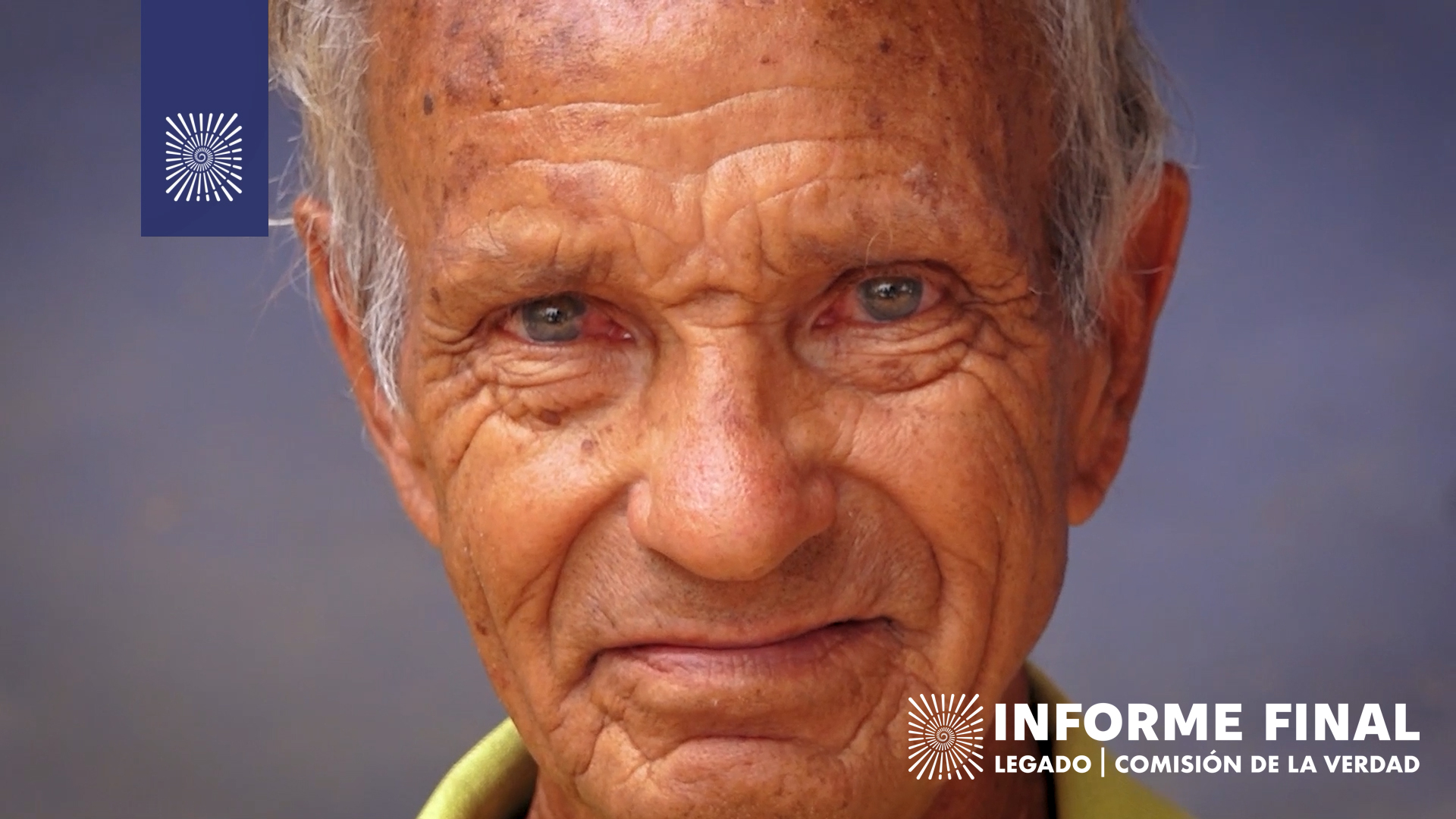 Rostro de un adulto mayor blanco, de ojos claros y pelo blanco mirando a cámara