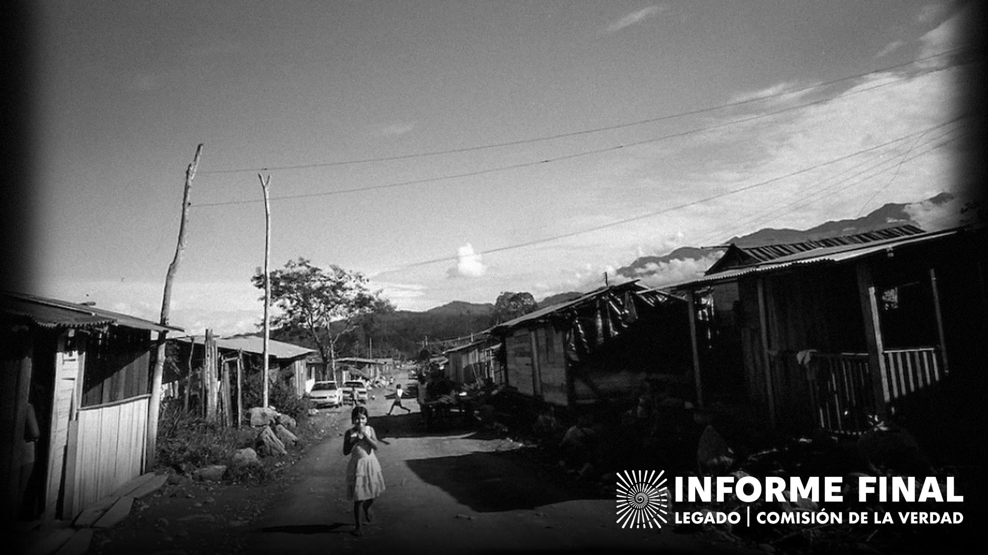 Niña caminando por calle despavimentada de una población rural