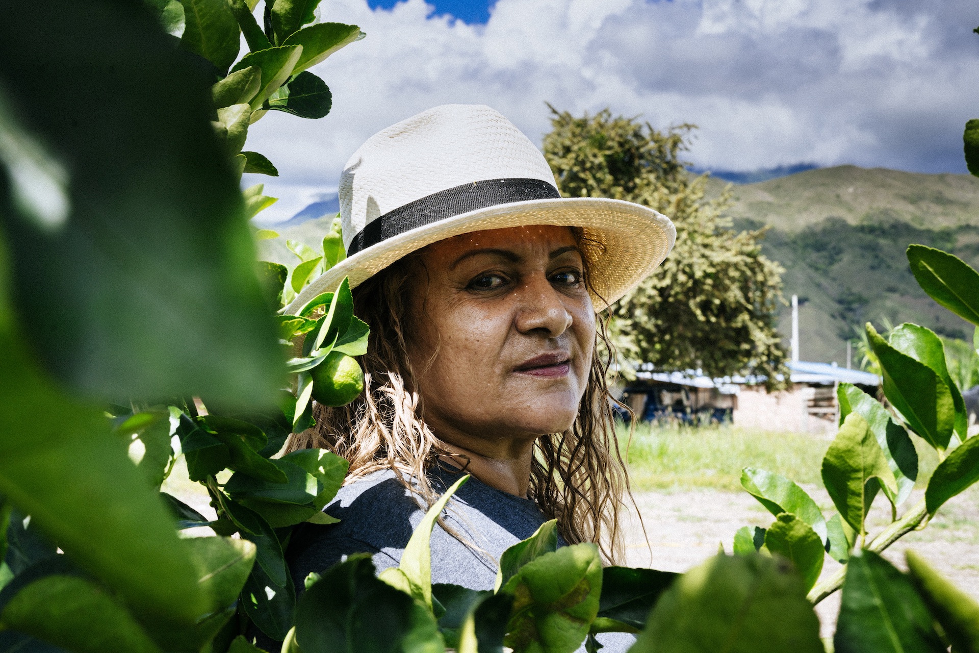 Rostro de mujer con pelo largo y sombrero mirando a la cámara 